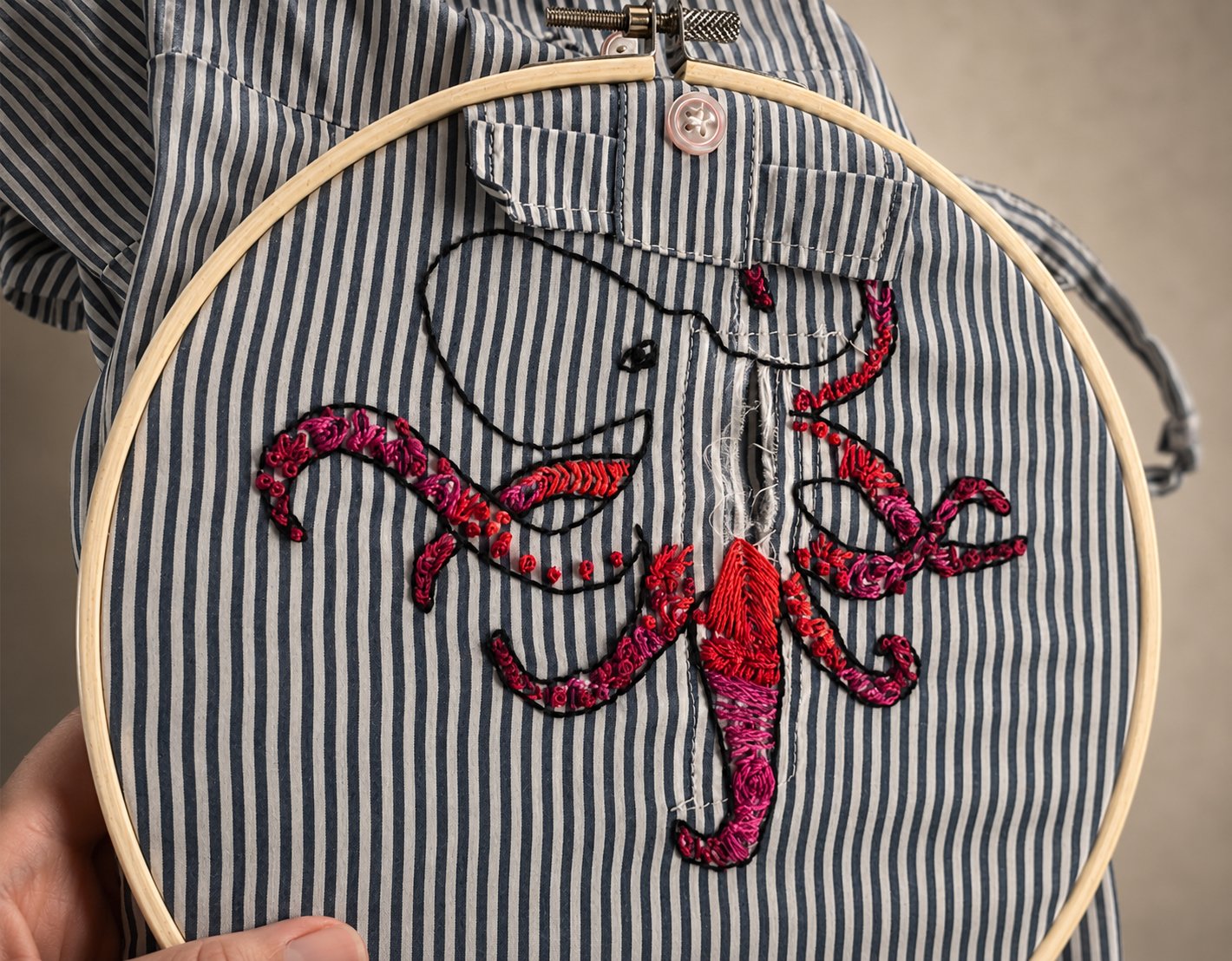 Visible mending — an embroidered octopus repair on a striped shirt