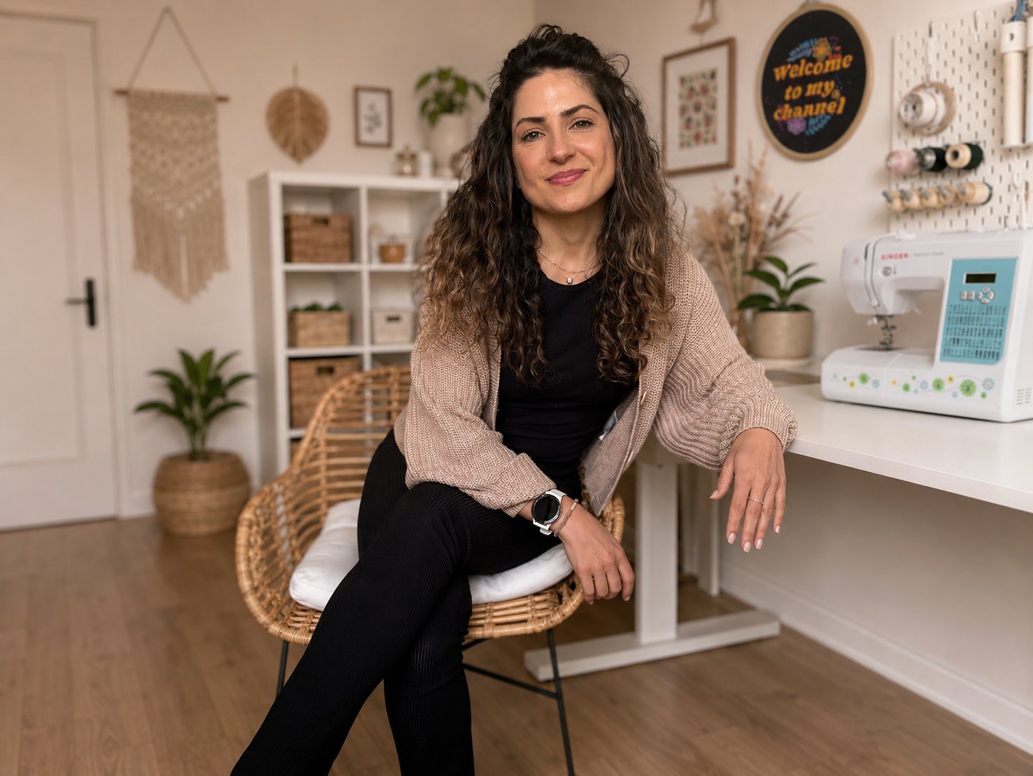 Valentina in her sewing studio, seated in a rattan chair with her sewing machine nearby